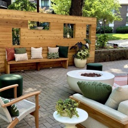 a patio with a bench and chairs